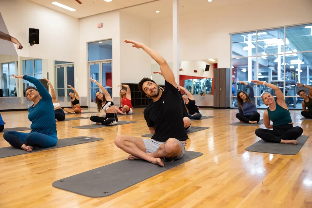 Male athlete doing stretches during a group fitness class at VASA Fitness