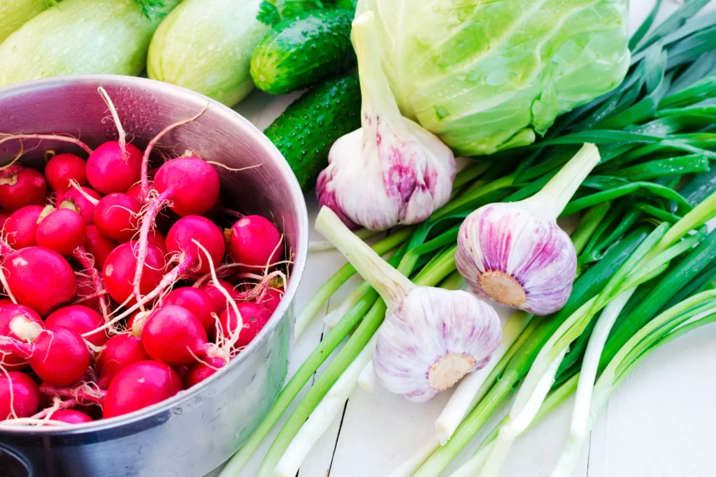 A bowl of radishes beside a group of raw radishes