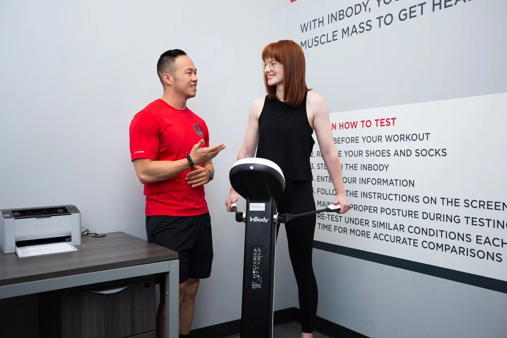 Female athlete doing an InBody scan with a personal trainer at VASA Fitness