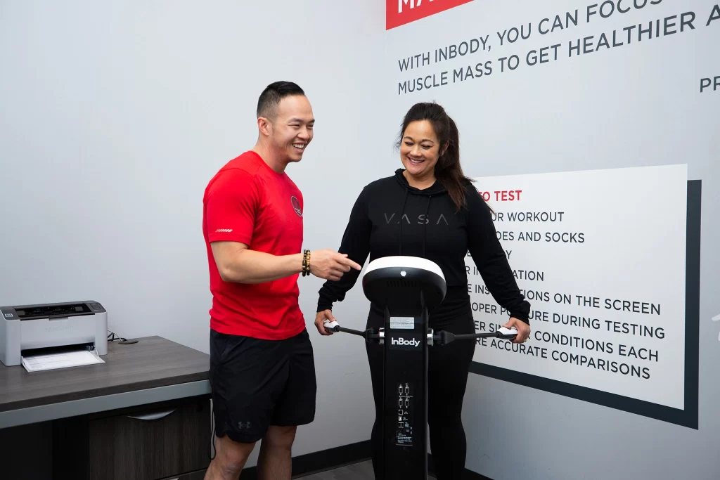 Female athlete with personal trainer doing an InBody Scan at VASA Fitness